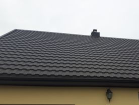 rudų metalinių čerpių stogas