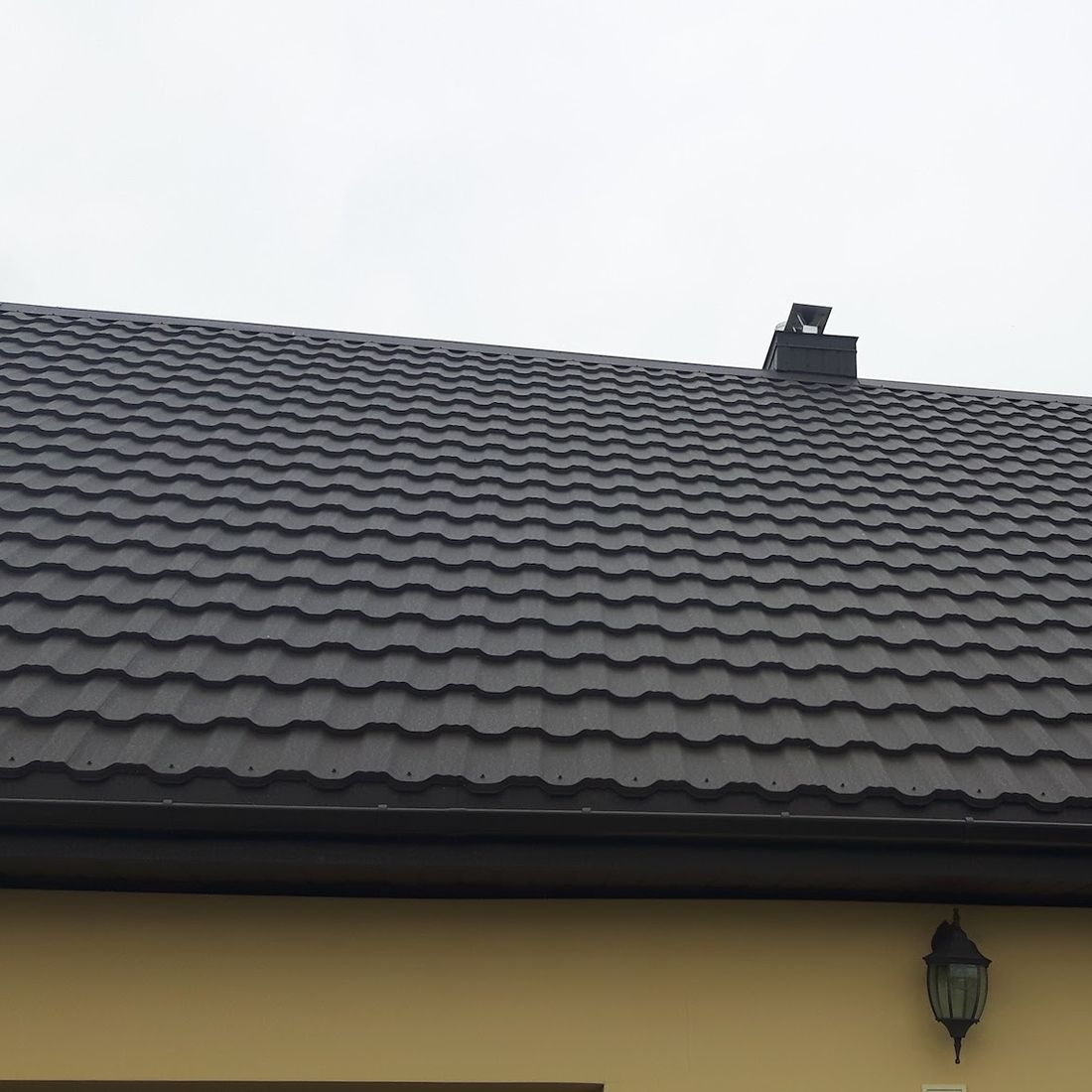 rudų metalinių čerpių stogas